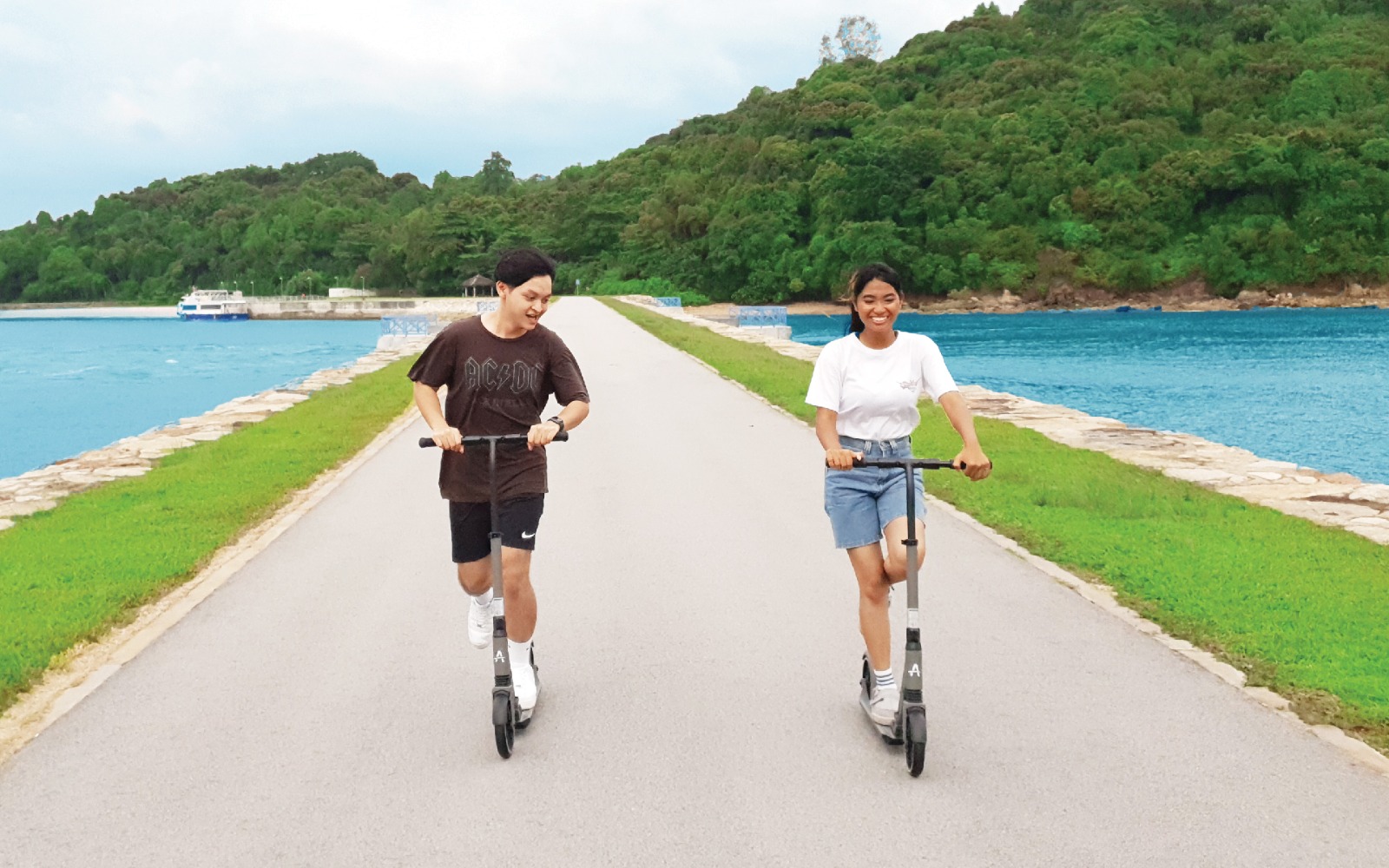 Couple enjoying themselves with kick scooter by the sea with Gogreen